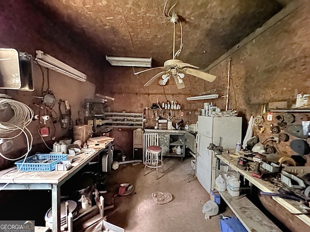 miscellaneous room featuring ceiling fan, a workshop area, and concrete floors