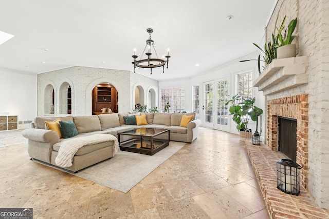 living room with a brick fireplace and a chandelier