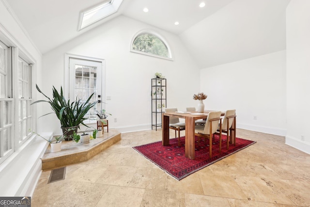 dining space featuring high vaulted ceiling