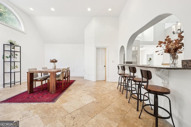 dining room featuring high vaulted ceiling