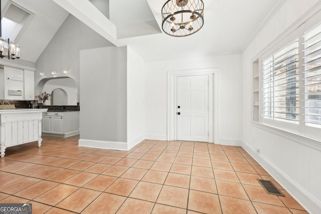 tiled entryway with a chandelier