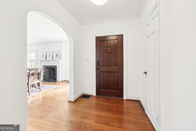 entryway with crown molding and hardwood / wood-style flooring