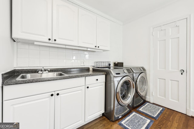 clothes washing area with independent washer and dryer, cabinets, dark hardwood / wood-style floors, and sink