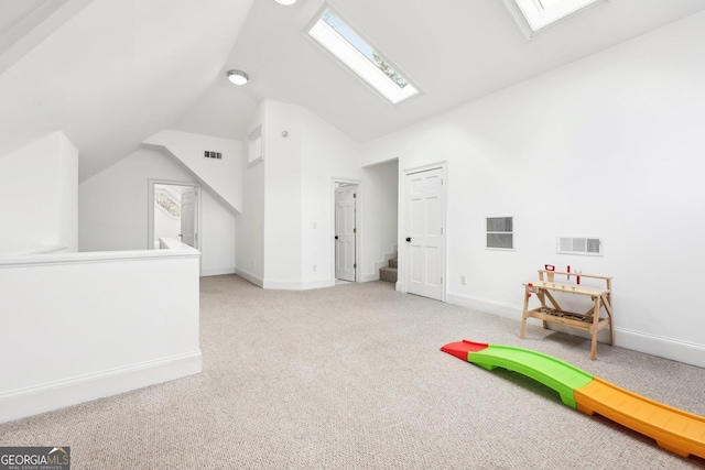 game room with light colored carpet and vaulted ceiling with skylight