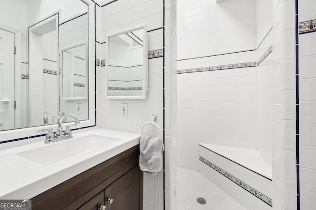 bathroom with vanity and tiled shower