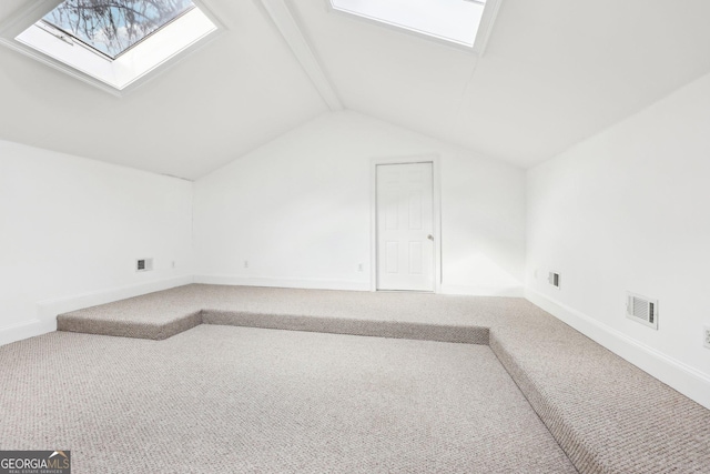 bonus room with carpet floors and vaulted ceiling with skylight