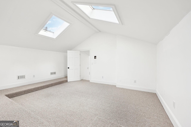 additional living space featuring carpet floors and vaulted ceiling with skylight