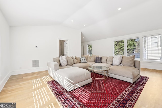 living room featuring vaulted ceiling and hardwood / wood-style floors