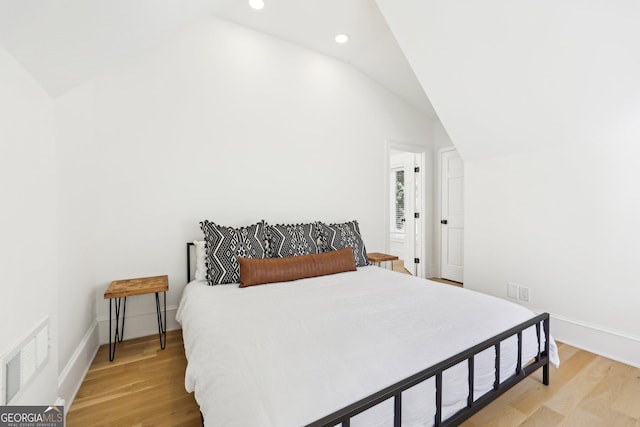 bedroom featuring vaulted ceiling and light hardwood / wood-style flooring