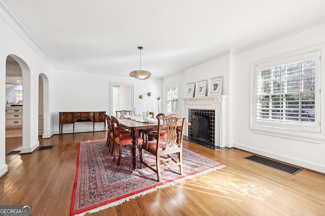 dining space with ornamental molding and wood-type flooring