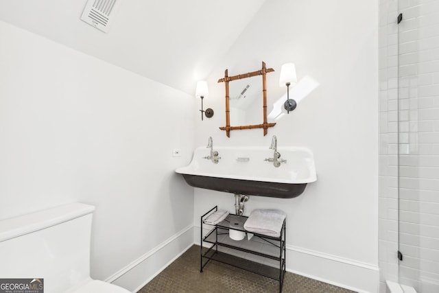 bathroom with sink, vaulted ceiling, and toilet