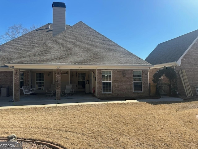 rear view of property with a yard and a patio area