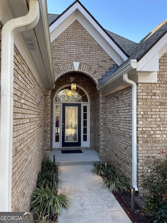 view of exterior entry with brick siding