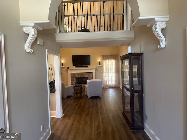 corridor featuring a towering ceiling and dark hardwood / wood-style floors