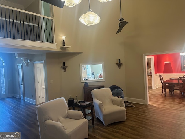 living room featuring dark wood-type flooring and a towering ceiling