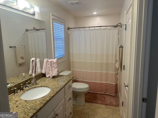 bathroom featuring tile patterned flooring, vanity, walk in shower, and toilet