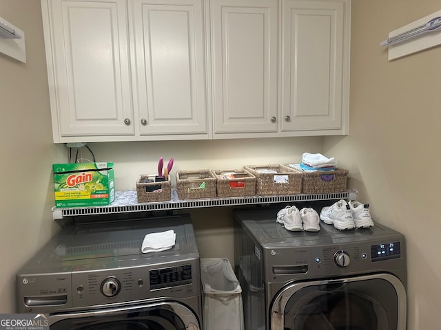 laundry room featuring cabinets and washing machine and clothes dryer