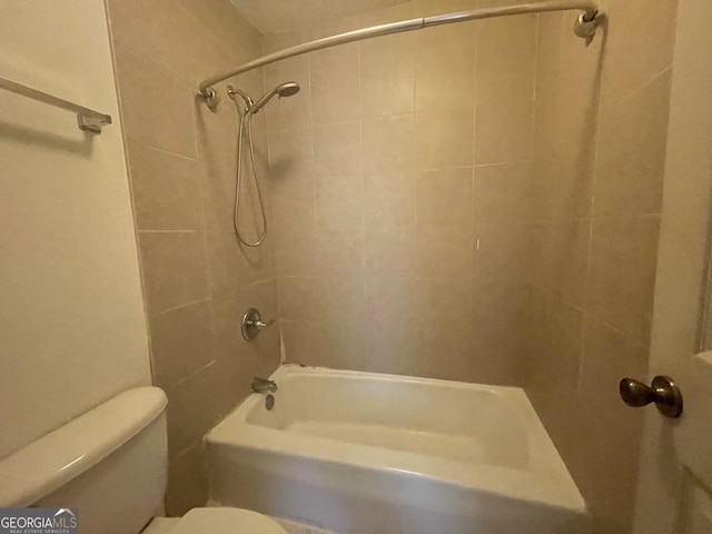 bathroom featuring tiled shower / bath and toilet