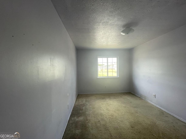 unfurnished room featuring carpet and a textured ceiling