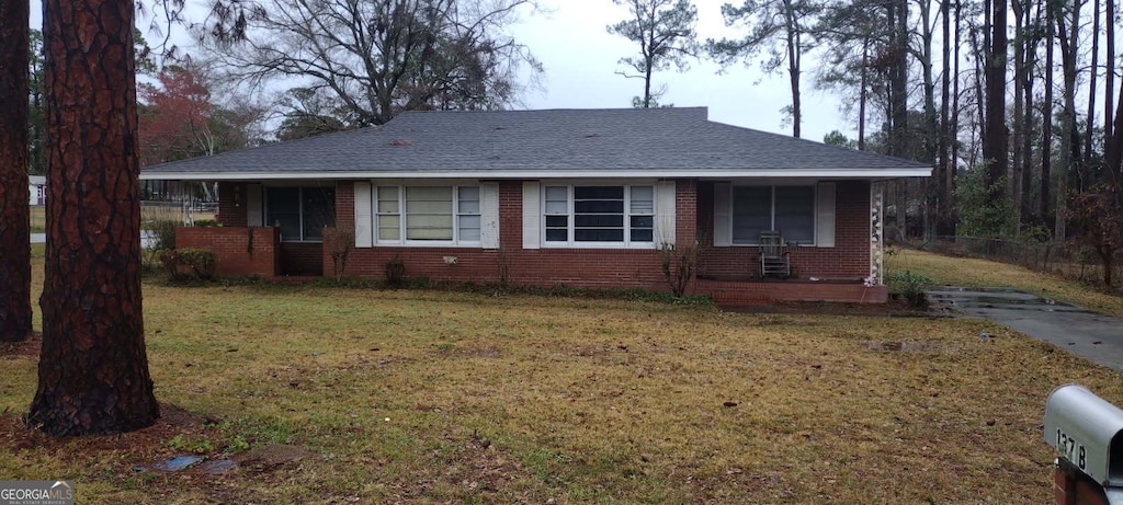 ranch-style house with a porch and a front lawn