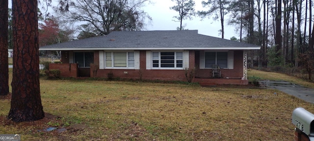 ranch-style house with a porch and a front lawn