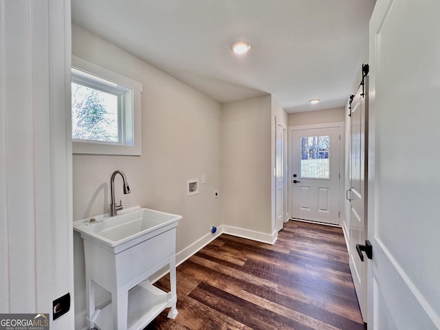 laundry room featuring a barn door, hookup for a washing machine, laundry area, dark wood-style flooring, and electric dryer hookup