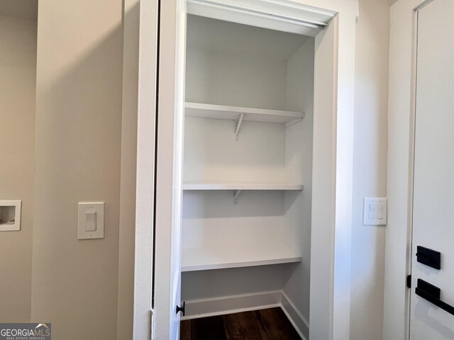 washroom with sink, electric dryer hookup, washer hookup, dark hardwood / wood-style flooring, and a barn door