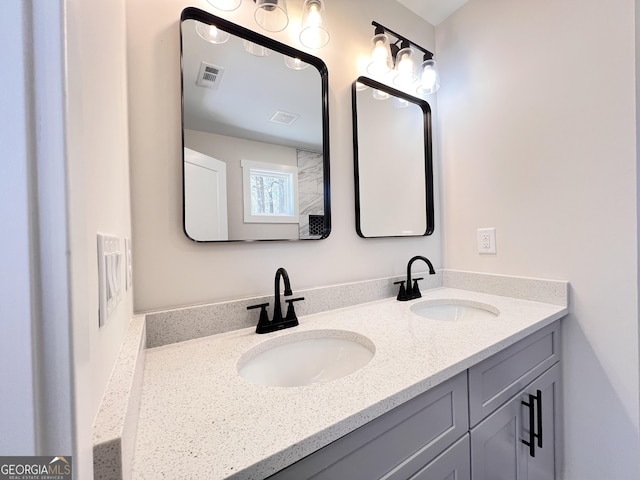 bathroom featuring double vanity, a sink, and visible vents