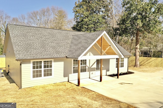 back of property featuring a shingled roof, central AC, and a patio