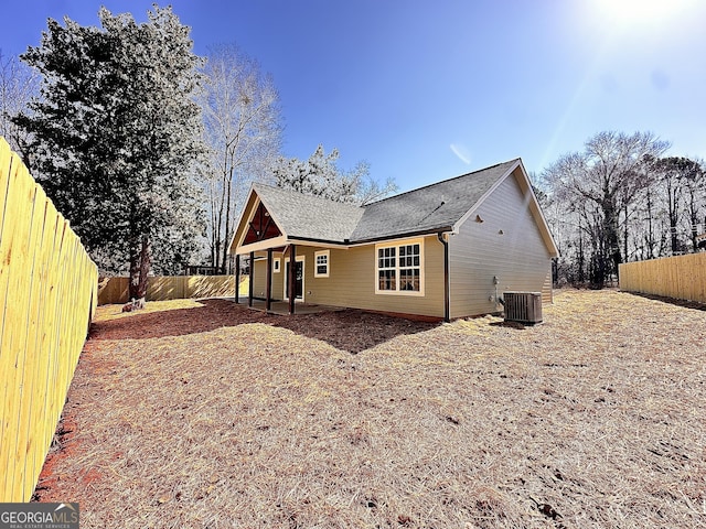 back of house featuring central AC unit and a fenced backyard