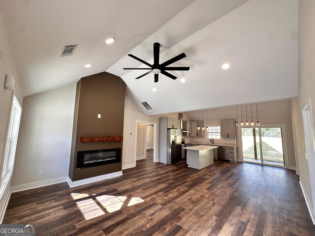 unfurnished living room featuring sink, high vaulted ceiling, dark hardwood / wood-style floors, and ceiling fan