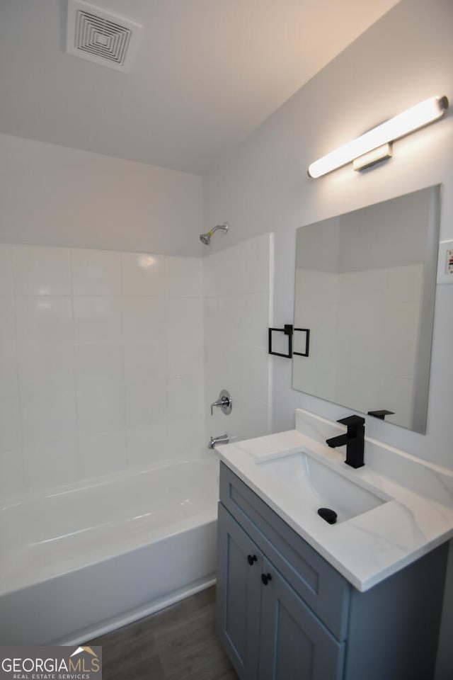 bathroom with vanity,  shower combination, and wood-type flooring