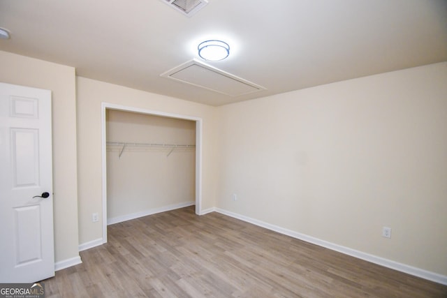 unfurnished bedroom featuring light hardwood / wood-style flooring and a closet