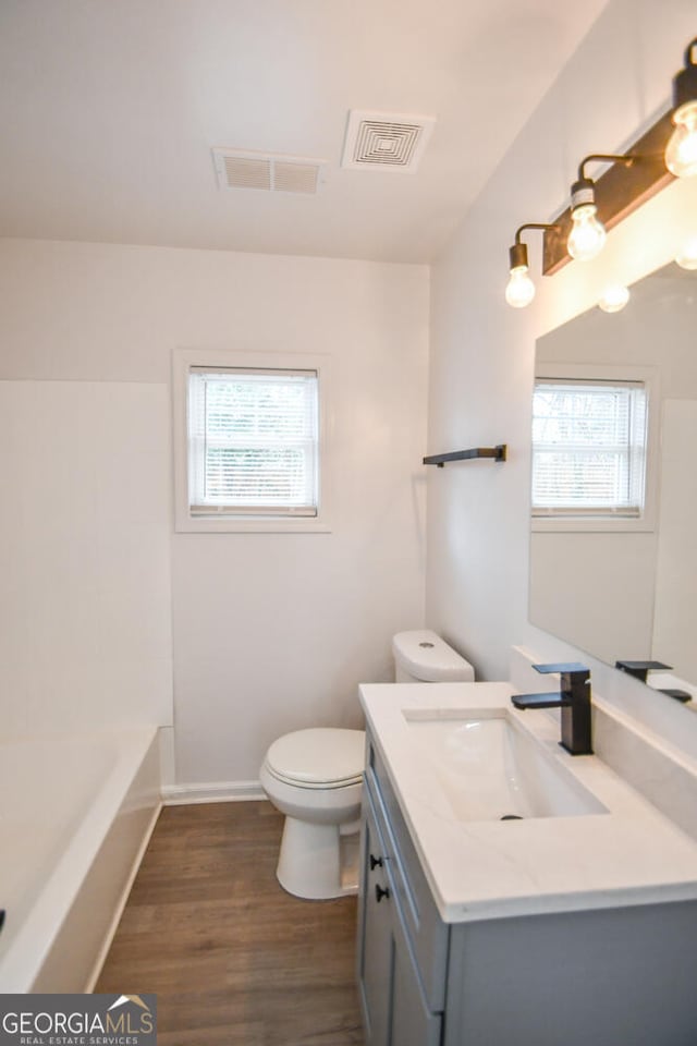 bathroom featuring vanity, hardwood / wood-style flooring, and toilet