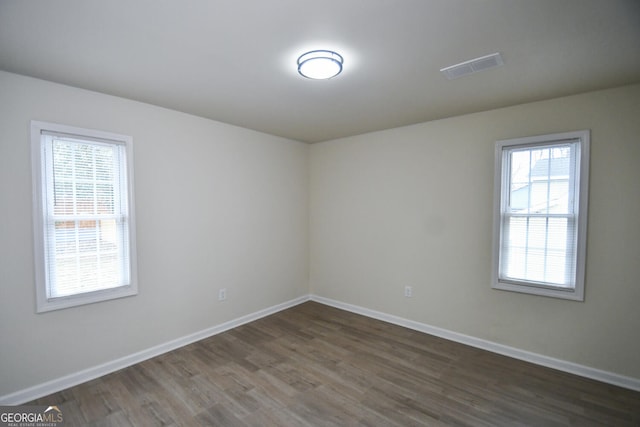 unfurnished room with dark wood-type flooring