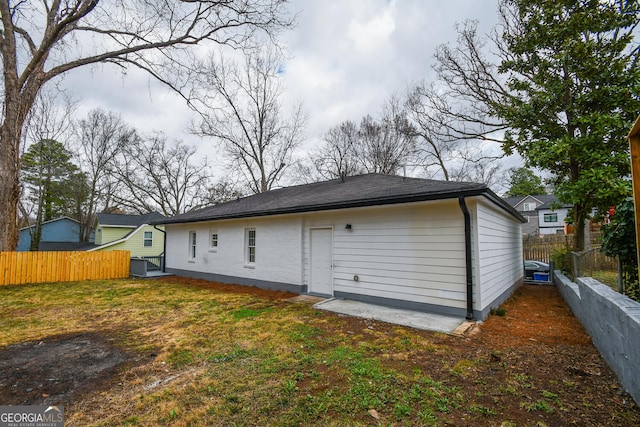 back of property featuring central AC and a lawn