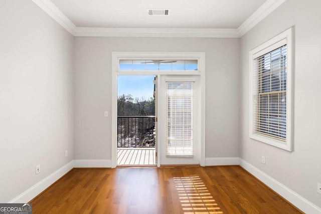 empty room featuring hardwood / wood-style flooring and ornamental molding