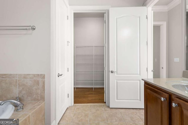 bathroom with vanity, tile patterned flooring, and tiled tub