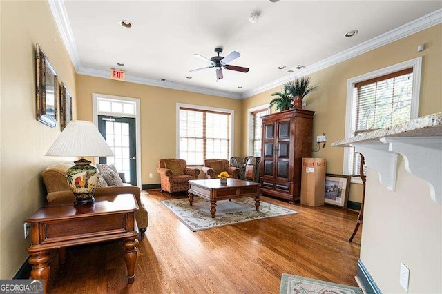 living room featuring hardwood / wood-style flooring, ornamental molding, and ceiling fan