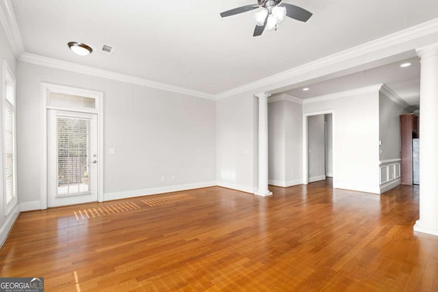 empty room with hardwood / wood-style floors, crown molding, decorative columns, and ceiling fan