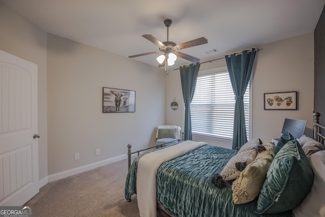 carpeted bedroom featuring visible vents, baseboards, and a ceiling fan