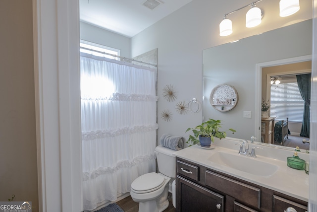 full bath with visible vents, shower / tub combo with curtain, vanity, and toilet