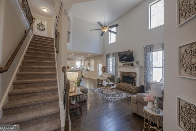 living area featuring stairway, a fireplace, dark wood finished floors, and a wealth of natural light