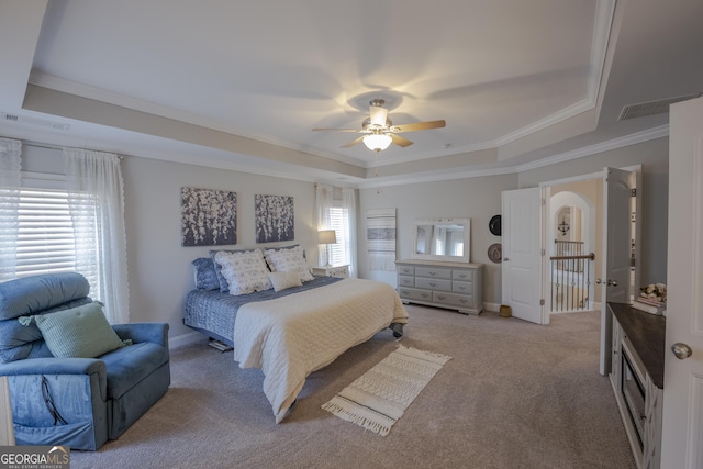 bedroom featuring multiple windows, visible vents, and a raised ceiling