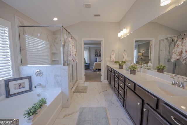 ensuite bathroom with double vanity, lofted ceiling, visible vents, connected bathroom, and a sink