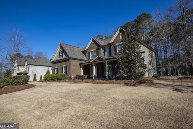 craftsman inspired home featuring brick siding and a porch