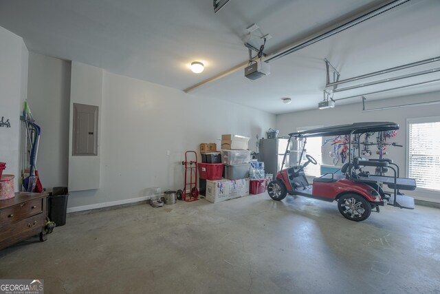 garage with baseboards, electric panel, and a garage door opener