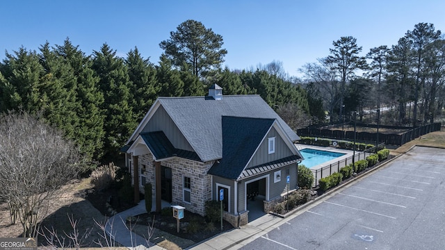 exterior space featuring central AC unit, fence, and a community pool