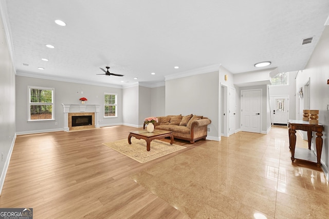 living room with crown molding, a fireplace, light hardwood / wood-style floors, and ceiling fan