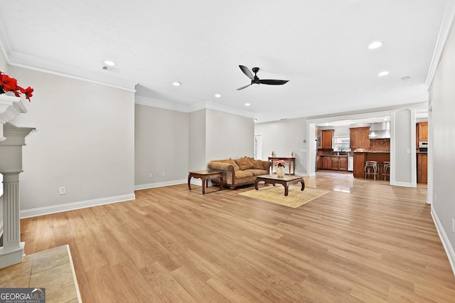 living room featuring crown molding, ceiling fan, and light wood-type flooring